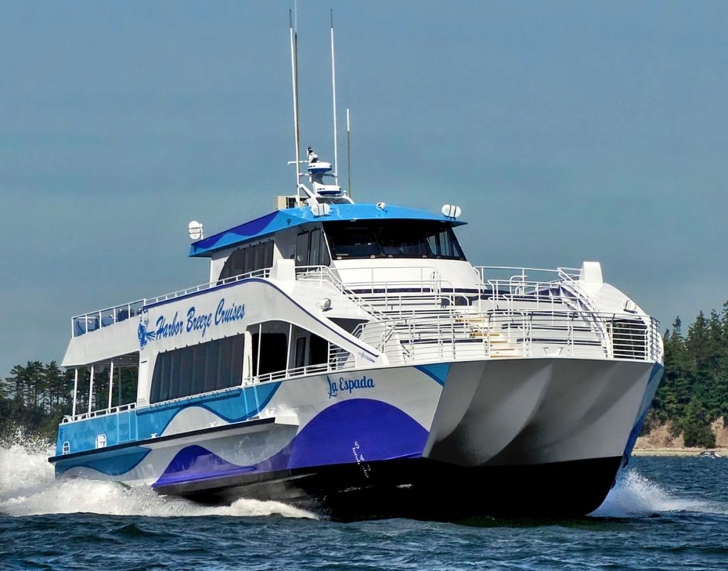 A large blue and white ferry sails on the water